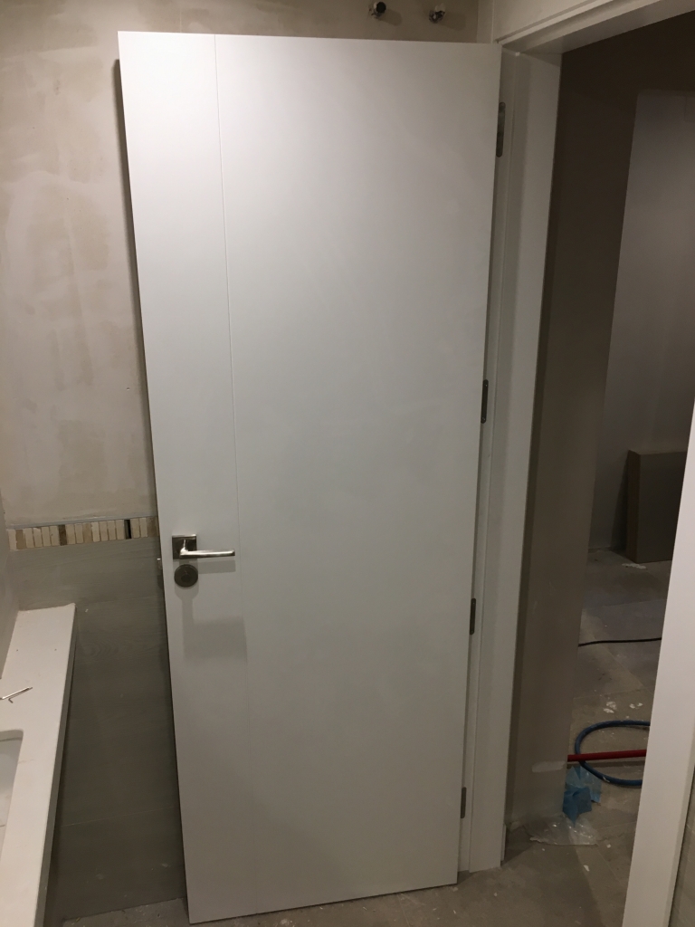 puerta lacada en blanco con una raya vertical en Granada